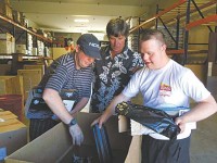 YEI!’s Executive Director Brad Newman (centre) assists YEI! employees Brock Wright (left) and Sky Casley (right) process used toner cartridges at YEI!’s Prescott Valley warehouse for QCOffice’s new toner cartridge recycling programme. (Credit: Max Efrein/The Daily Courier)